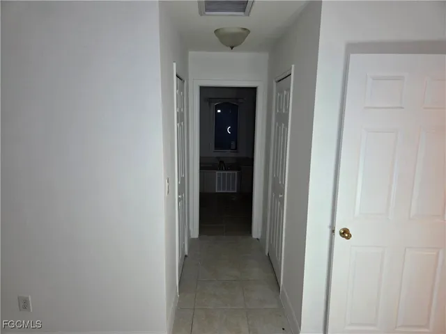 a view of a hallway to an empty room and closet