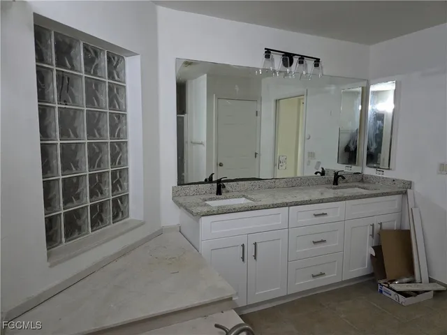a bathroom with a granite countertop sink and a mirror