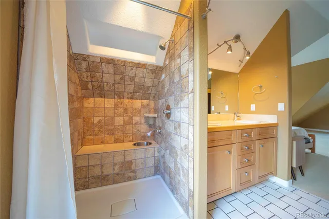 a bathroom with a double vanity sink a mirror and a shower