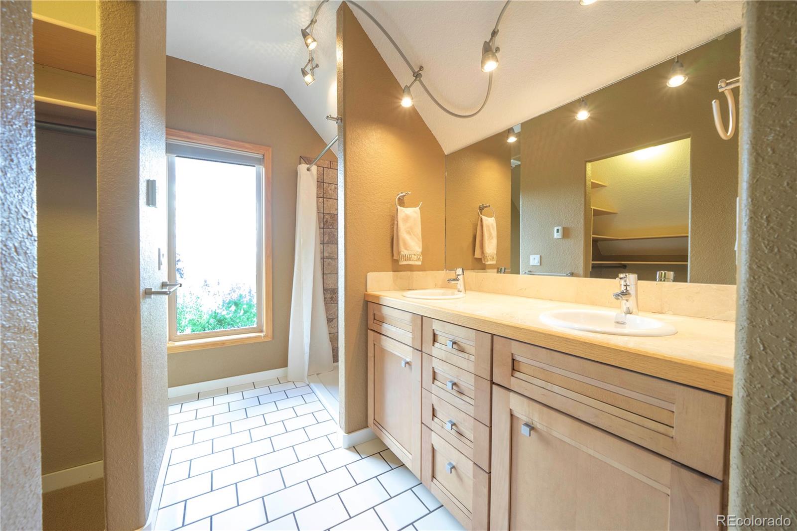 138 Teton Way Como, CO 80432 - Photo 16 of 34 a bathroom with a double vanity sink a mirror and a shower