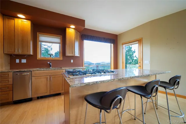 a kitchen with granite countertop a stove a sink and cabinets