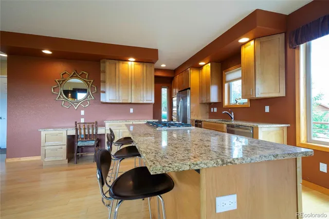 a kitchen with kitchen island granite countertop a table and chairs in it