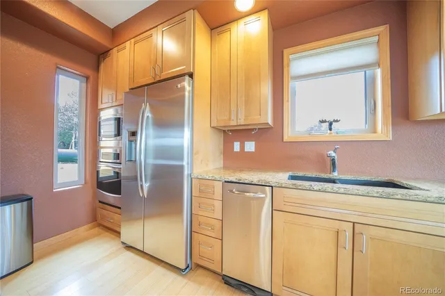 a kitchen with stainless steel appliances granite countertop a refrigerator and a sink