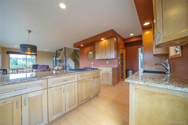 a large kitchen with granite countertop a sink and a refrigerator