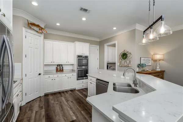 a kitchen with stainless steel appliances white cabinets and a refrigerator