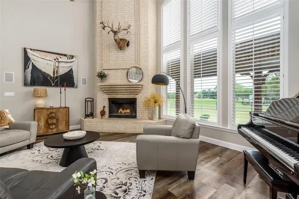 a living room with furniture a fireplace and a floor to ceiling window