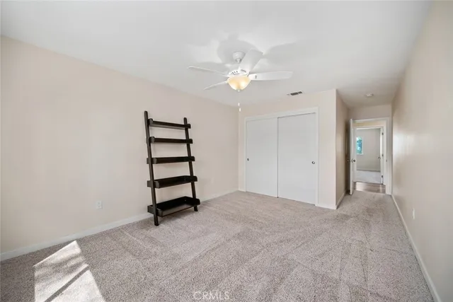 an empty room with a ceiling fan and a window