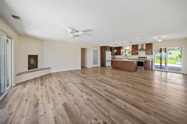 a view of kitchen with kitchen island microwave and wooden floor