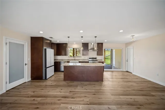 a view of kitchen with stainless steel appliances granite countertop refrigerator oven a sink a dining table and chairs