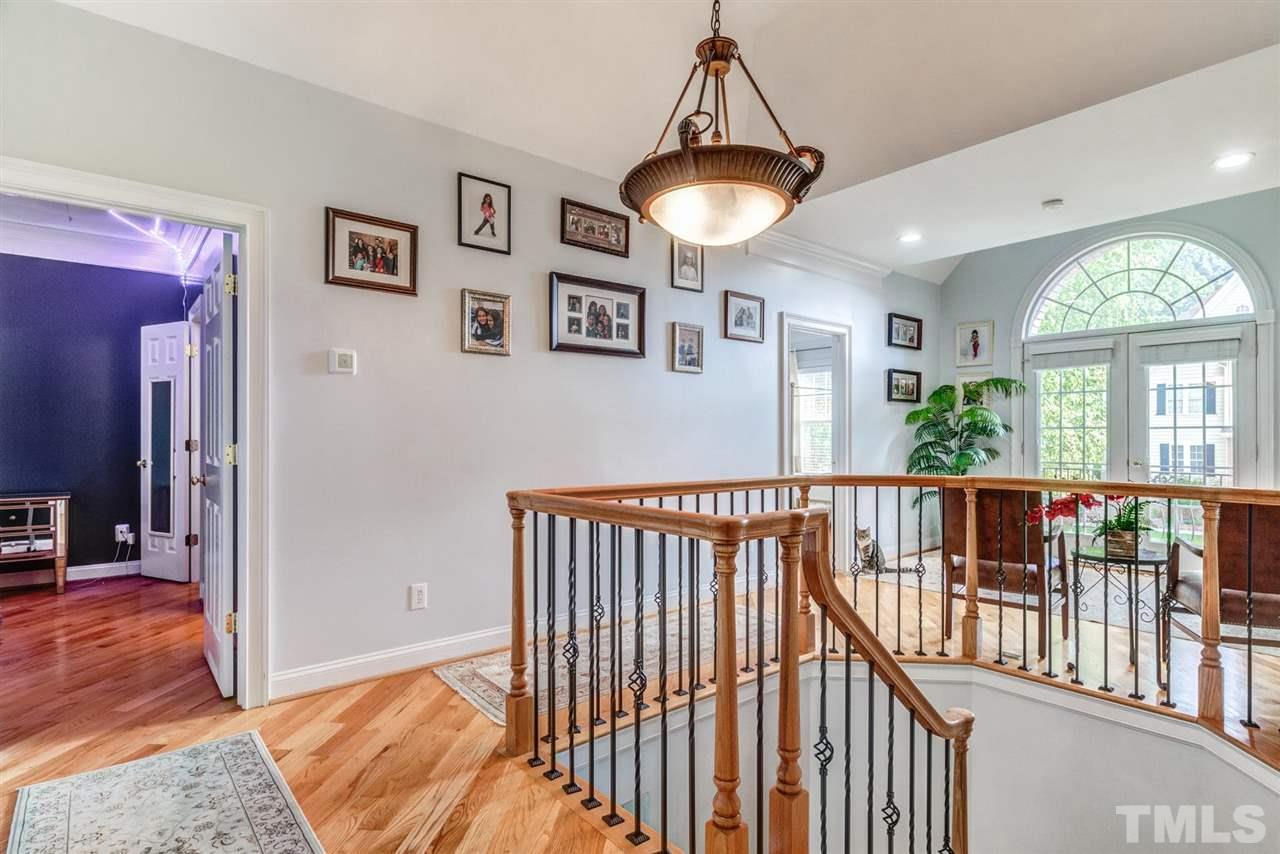 12249 Beestone Lane Raleigh, NC 27614 - Photo 20 of 29 a view of hallway with wooden floor and a chandelier