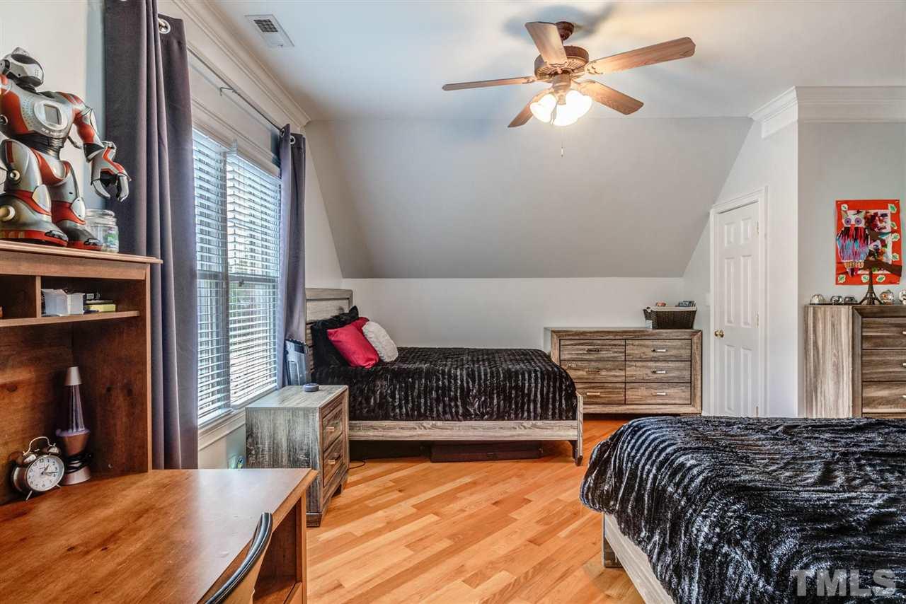 12249 Beestone Lane Raleigh, NC 27614 - Photo 21 of 29 a bedroom with a bed and a chandelier