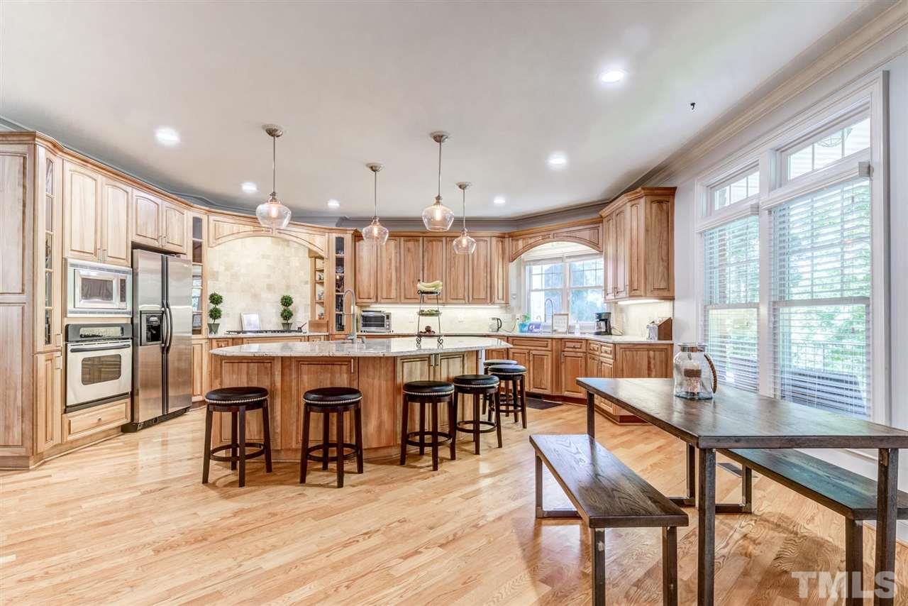 12249 Beestone Lane Raleigh, NC 27614 - Photo 7 of 29 a dining room with stainless steel appliances kitchen island granite countertop a dining table chairs and granite counter tops