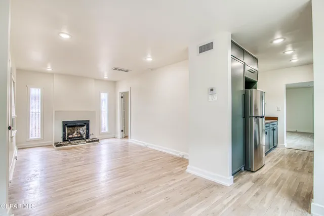 a kitchen with stainless steel appliances granite countertop a refrigerator a stove and a sink