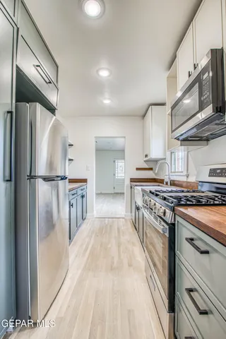 a kitchen with stainless steel appliances granite countertop a sink a stove and cabinets