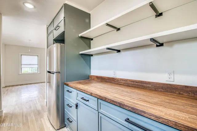 a kitchen with stainless steel appliances granite countertop a refrigerator and a sink