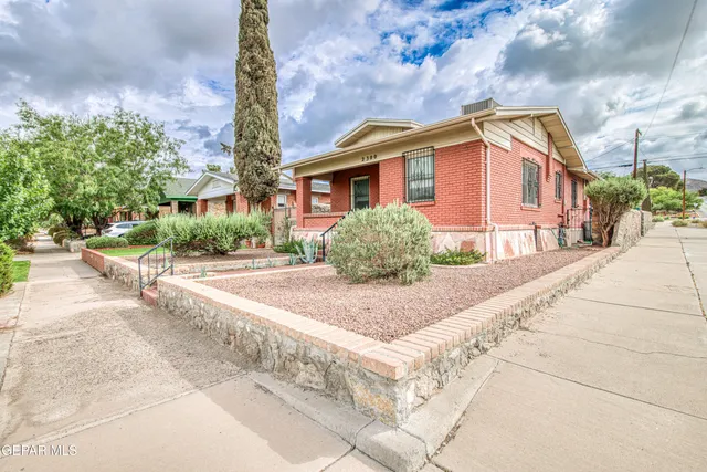 a front view of a house with a yard and trees
