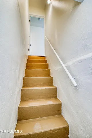a front view of a house with a yard and potted plants