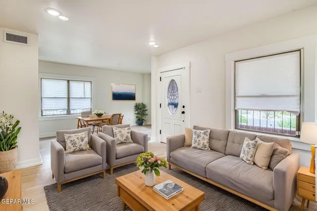 an empty room with wooden floor fireplace and windows