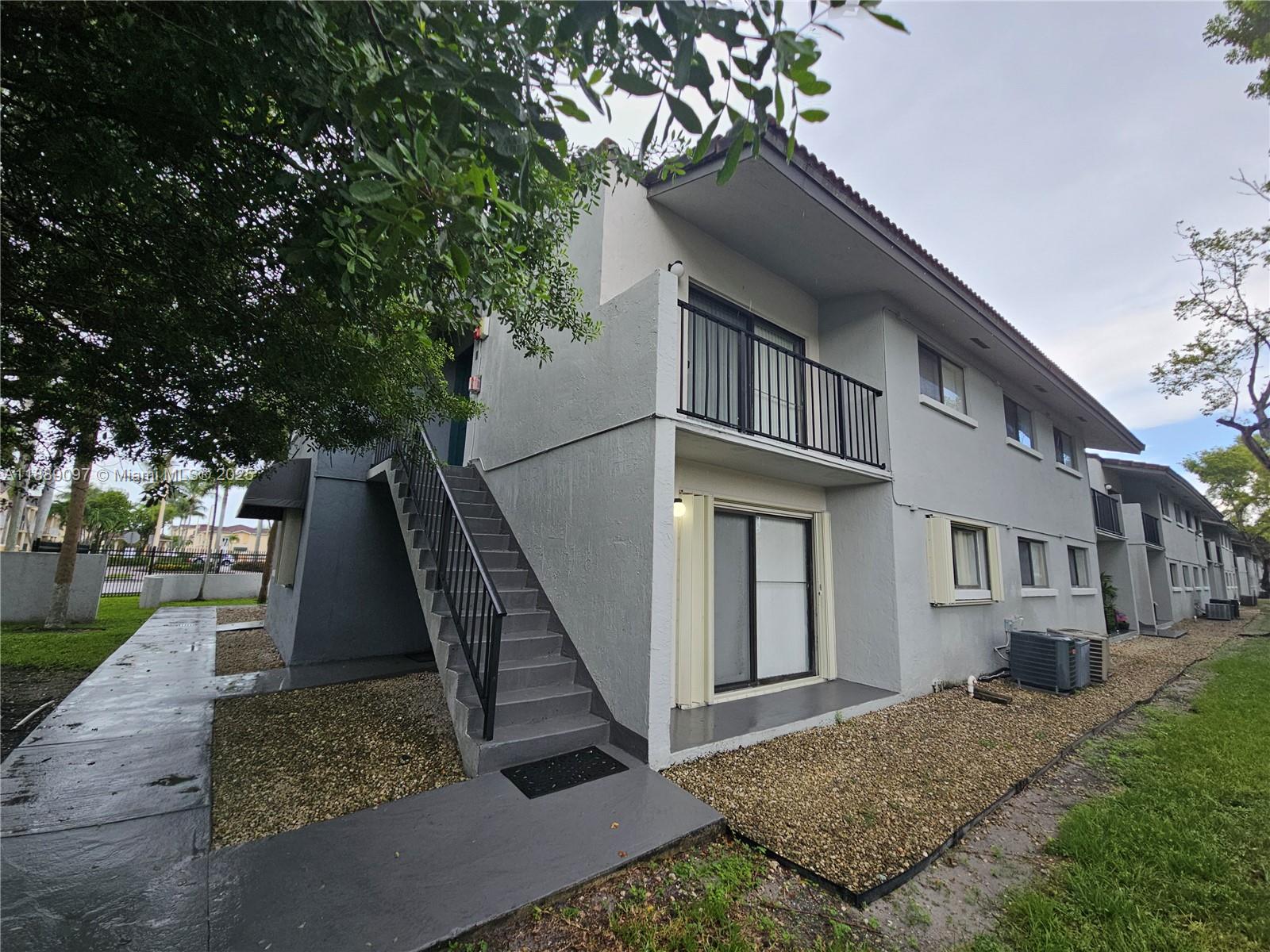 6901 Northwest 179th Street, Unit 212 Hialeah, FL 33015 - Photo 1 of 5 a view of a house with a yard