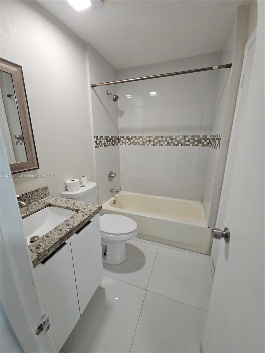 6901 Northwest 179th Street, Unit 212 Hialeah, FL 33015 - Photo 5 of 5 a bathroom with a granite countertop sink toilet and shower