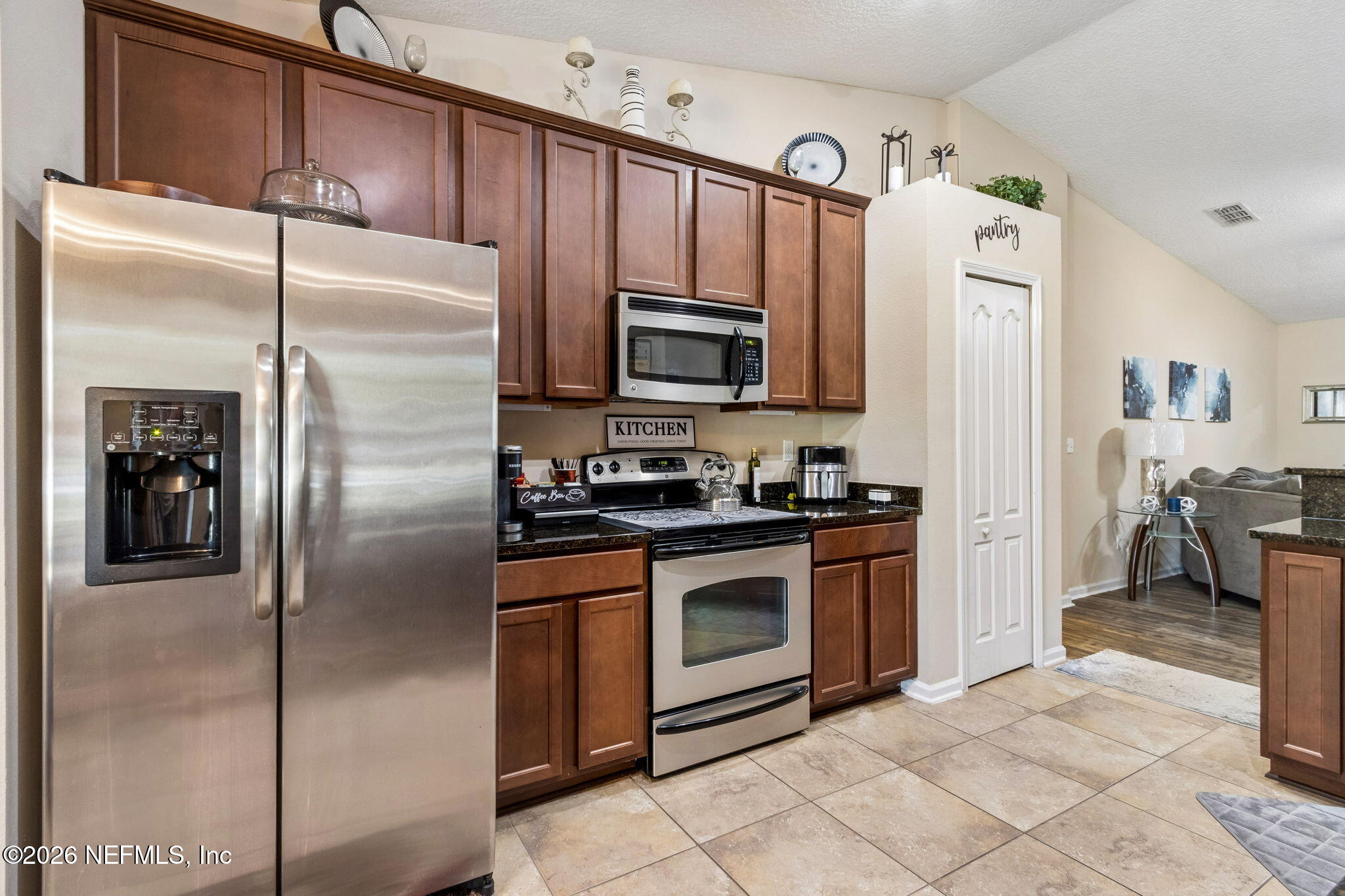 96034 Bass Lane Yulee, FL 32097 - Photo 21 of 50 a kitchen with granite countertop a refrigerator stove and microwave