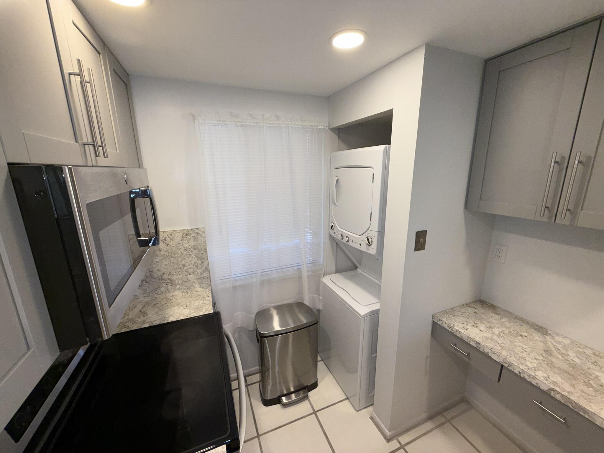 2788 Tennis Club Drive, Unit 203 West Palm Beach, FL 33417 - Photo 2 of 10 a bathroom with a granite countertop sink toilet and shower