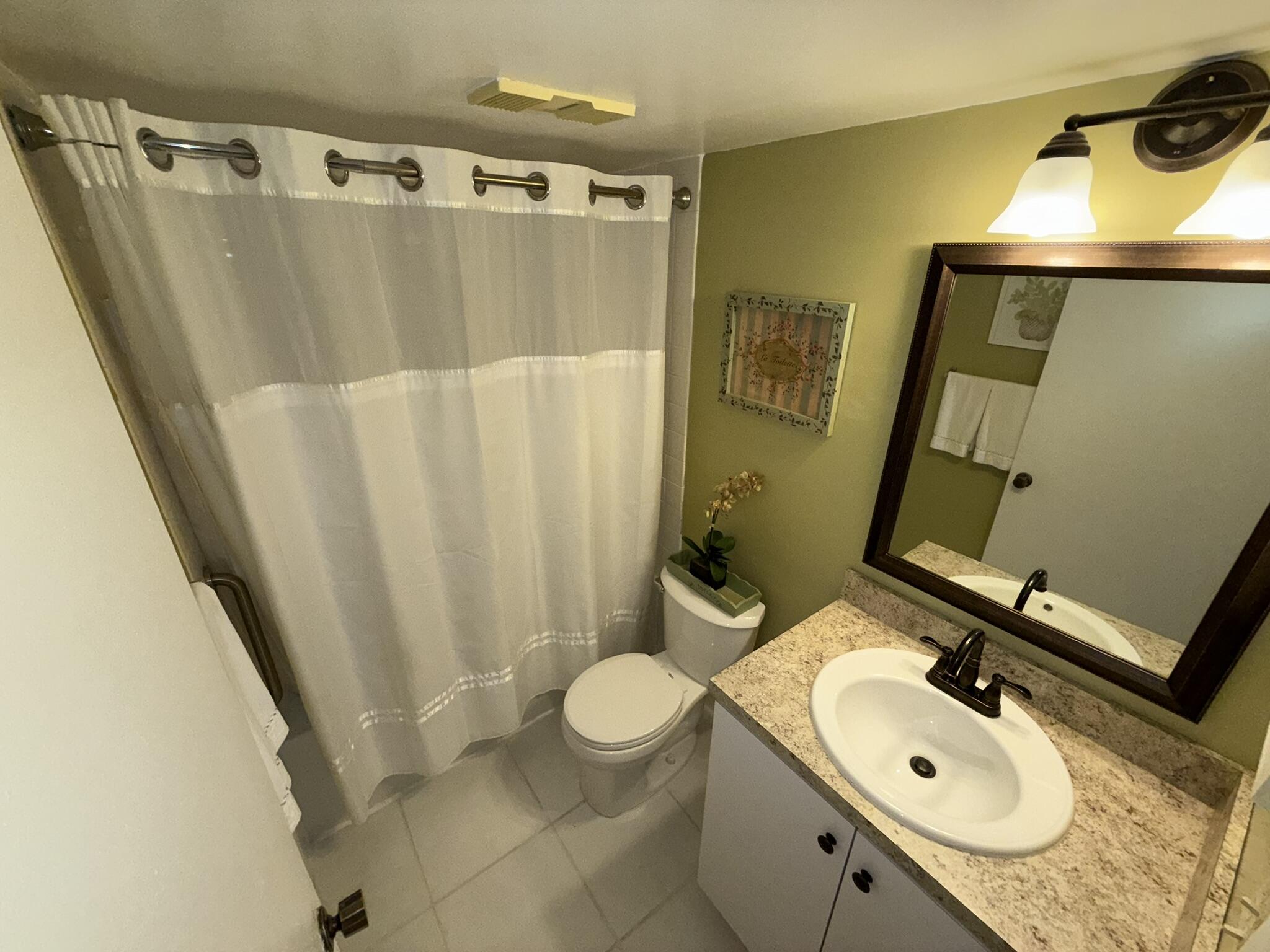 2788 Tennis Club Drive, Unit 203 West Palm Beach, FL 33417 - Photo 6 of 10 a bathroom with a sink a toilet and shower
