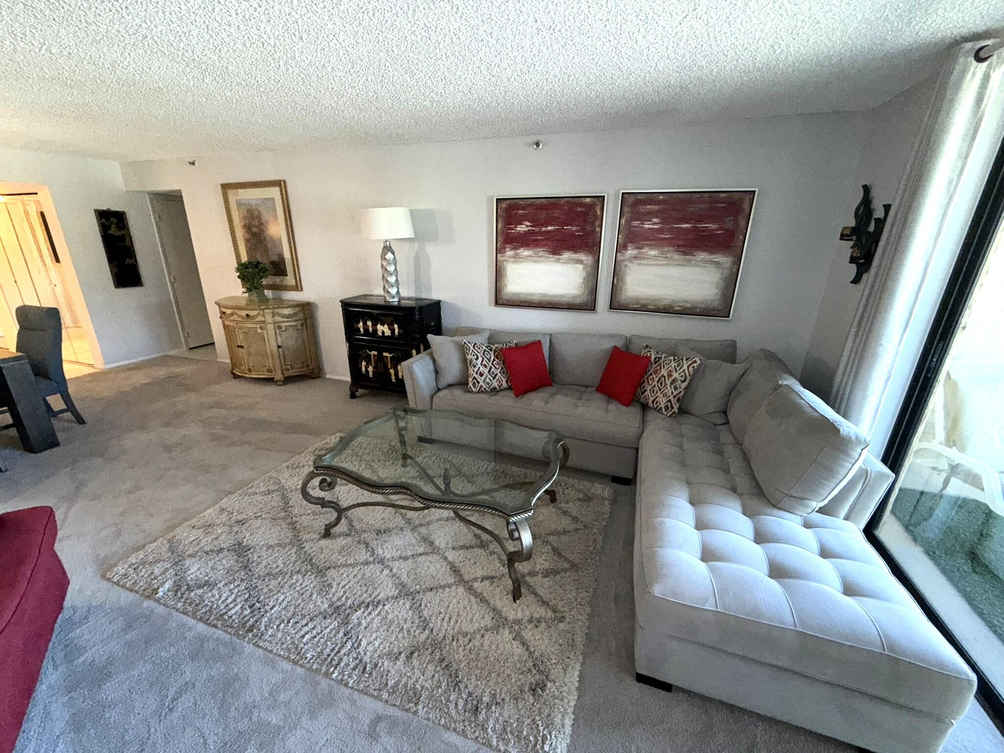 2788 Tennis Club Drive, Unit 203 West Palm Beach, FL 33417 - Photo 9 of 10 a living room with furniture and a flat screen tv