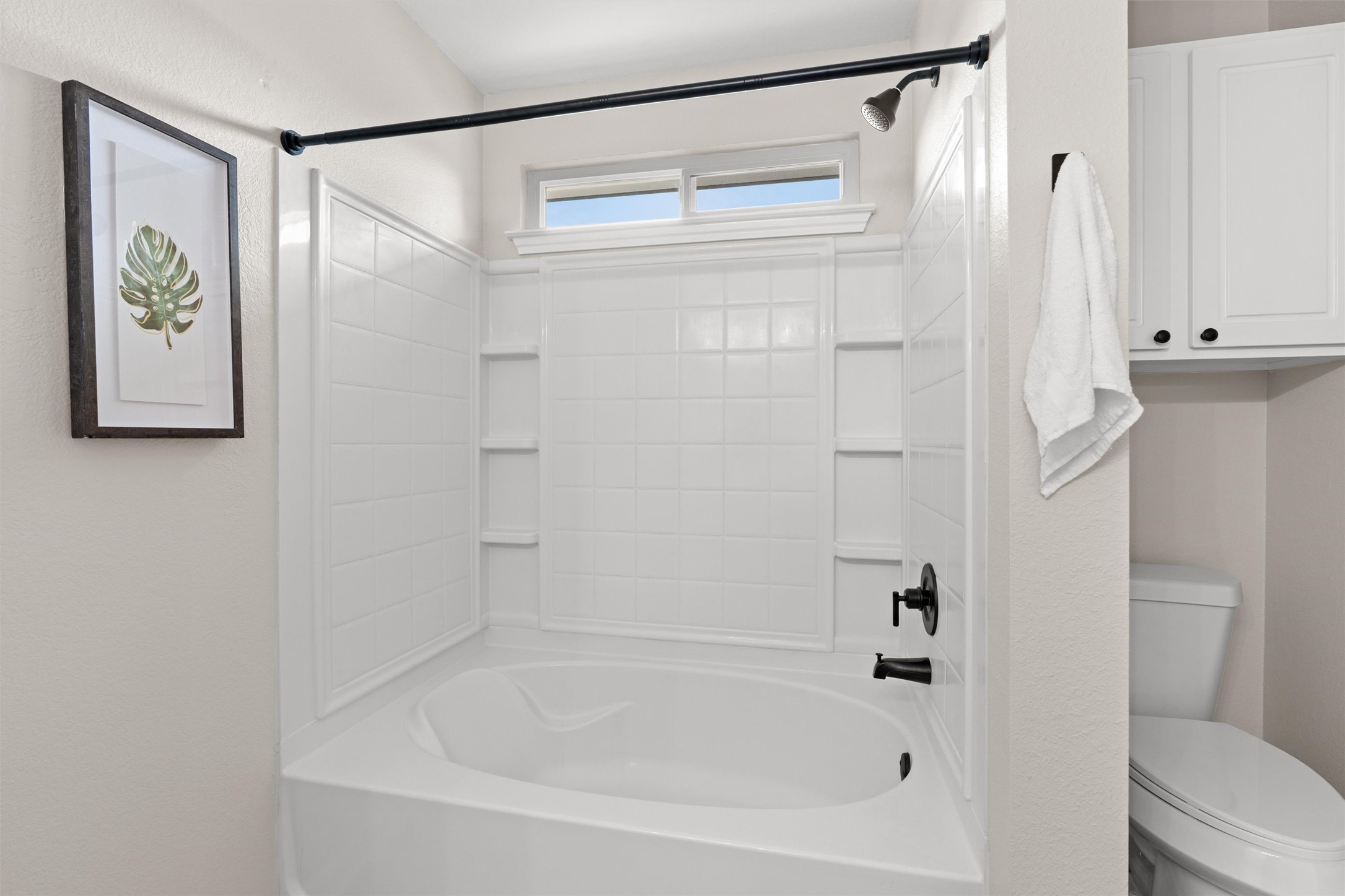 724 Lavaca Loop Elgin, TX 78621 - Photo 17 of 40 A classic bathtub and shower combination is framed by crisp tiled walls and built-in shelving.