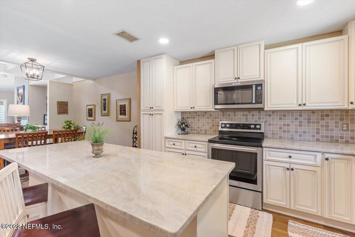 75 Fishermans Cove Road Ponte Vedra Beach, FL 32082 - Photo 7 of 47 a kitchen with stainless steel appliances a stove sink microwave and cabinets