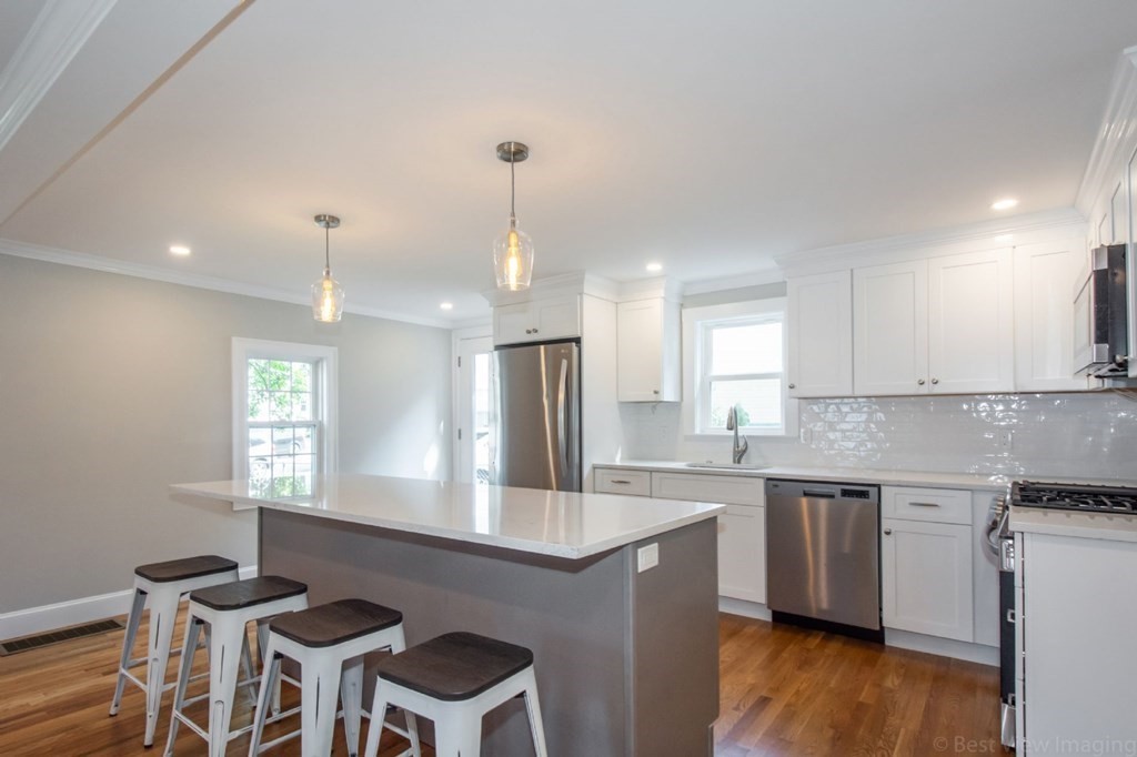 214 Riverside Drive Dedham, MA 02026 - Photo 3 of 26 a kitchen with a sink cabinets and wooden floor