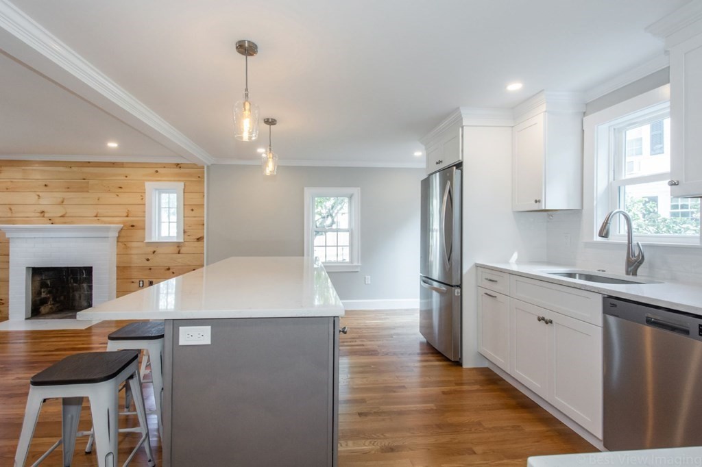 214 Riverside Drive Dedham, MA 02026 - Photo 5 of 26 a kitchen with stainless steel appliances granite countertop a refrigerator a sink dishwasher a stove and a dining table with wooden floor