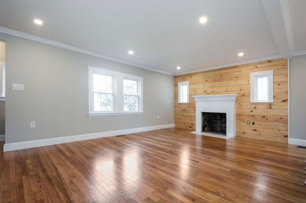 214 Riverside Drive Dedham, MA 02026 - Photo 9 of 26 an empty room with wooden floor fireplace and windows