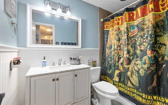 a bathroom with a sink a toilet and a mirror