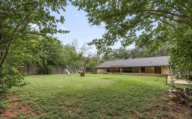 a view of big yard with a house in the background