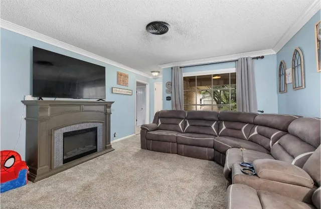 a living room with furniture a flat screen tv and a fireplace