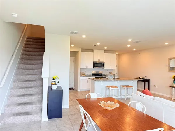 a view of a livingroom with a white wall and stairs