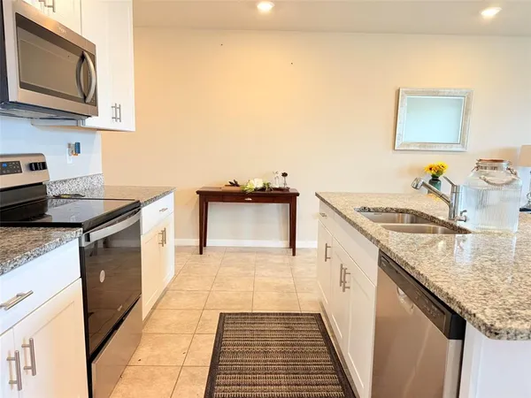 a kitchen with a sink a stove and a microwave