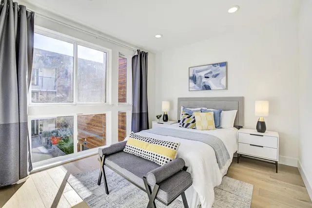 a bedroom with a bed and a large window