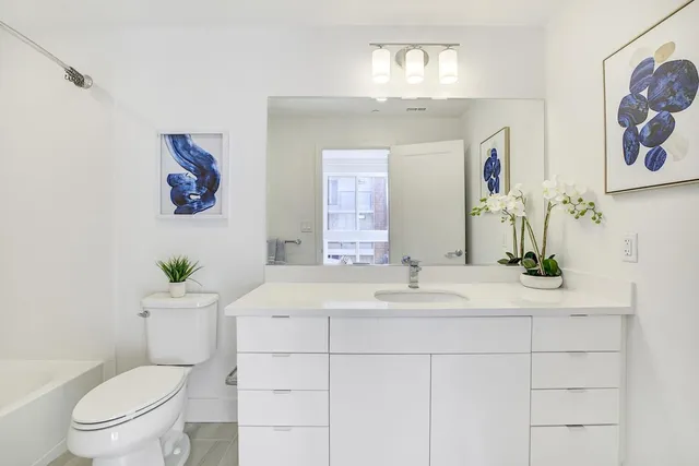 a bathroom with a sink mirror and toilet