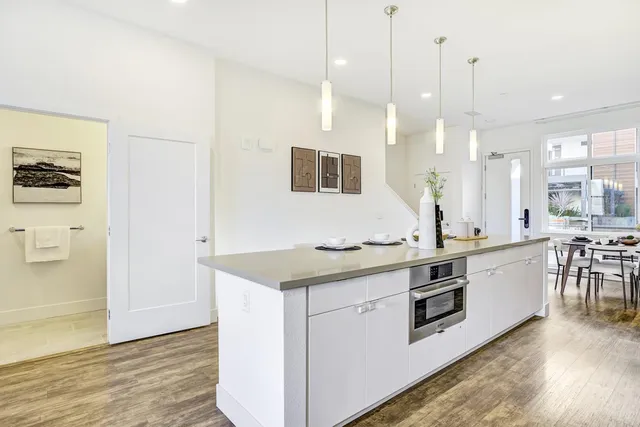a kitchen with stainless steel appliances sink stove and wooden floor