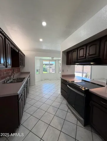 a kitchen with granite countertop a sink stove top oven and cabinets