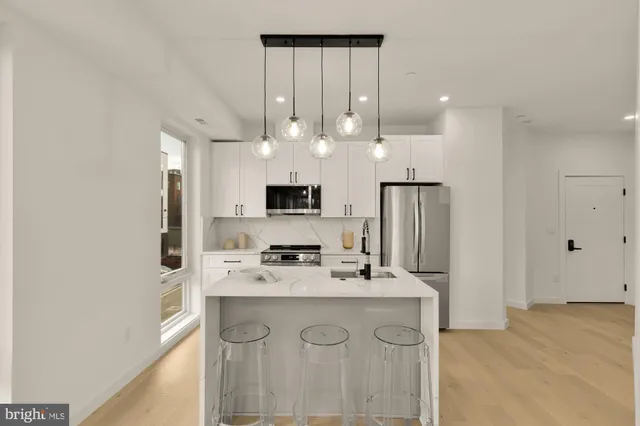 a kitchen with kitchen island a sink stainless steel appliances and cabinets