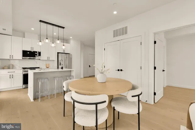 a kitchen with kitchen island a stove a table and chairs in it