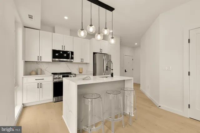 a kitchen with kitchen island granite countertop a sink a center island a stove and cabinets