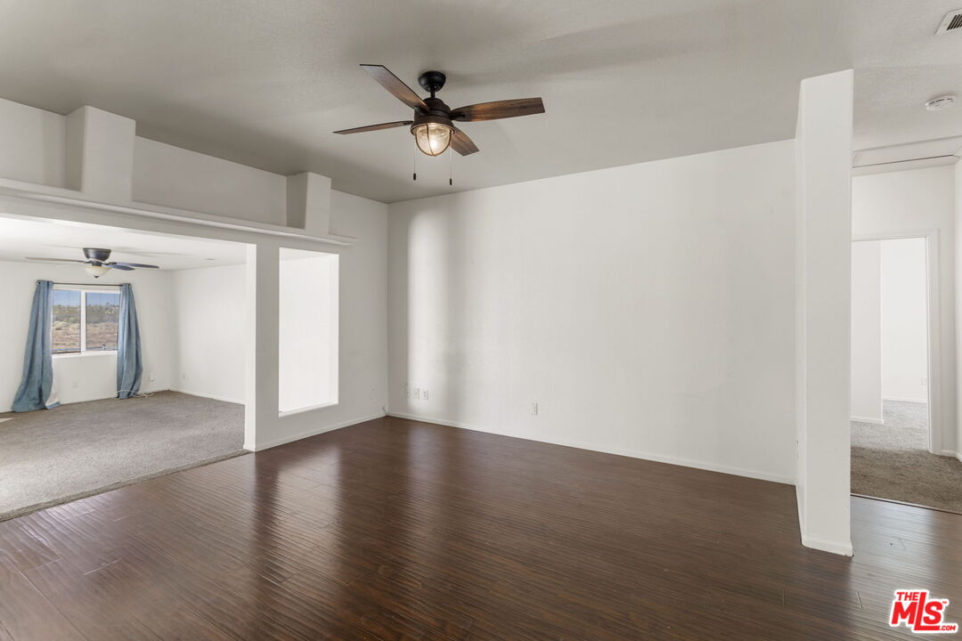 13072 Anderson Ranch Road Phelan, CA 92371 - Photo 8 of 25 a view of a livingroom with wooden floor and a ceiling fan