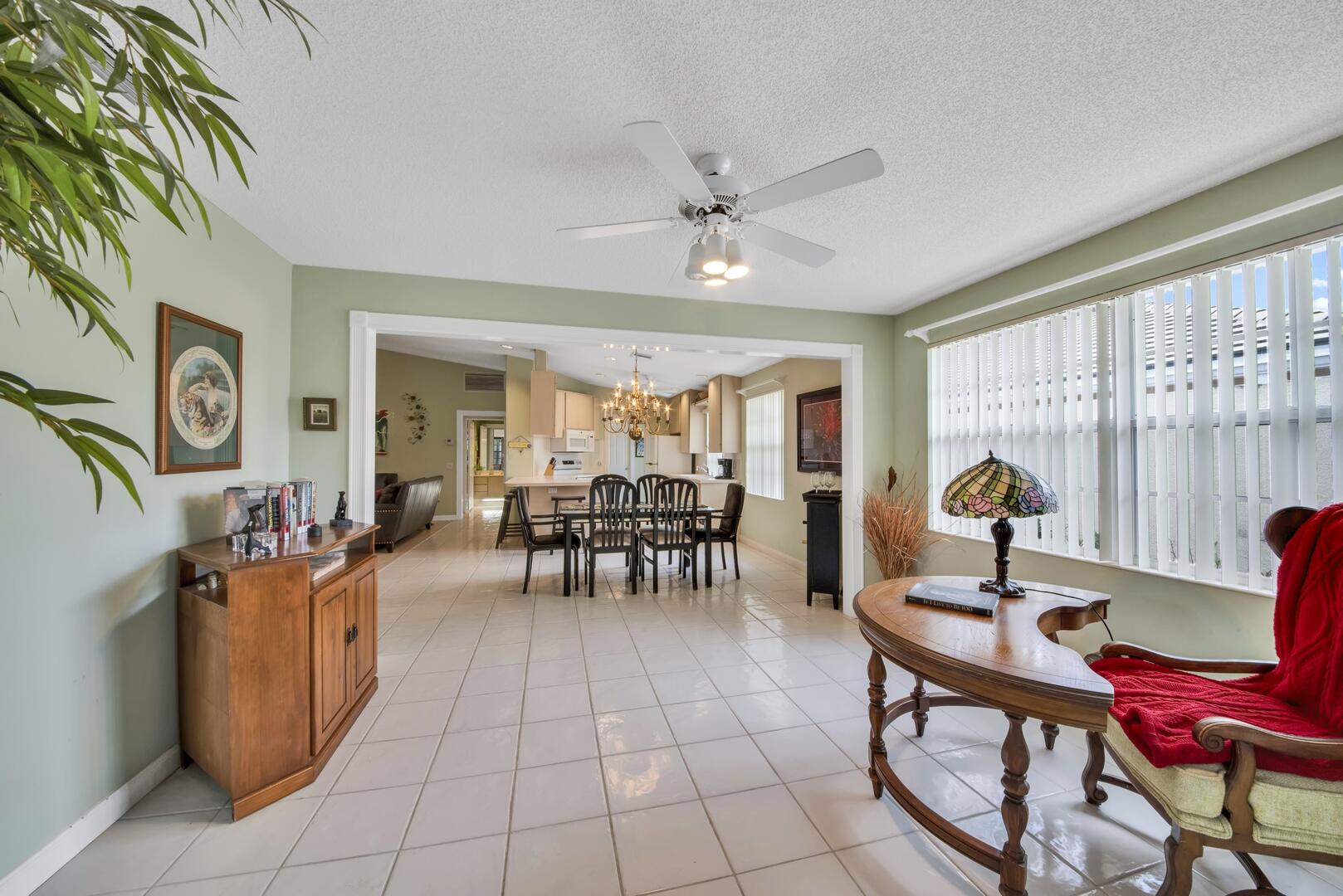 4220 Royal Oak Drive Palm Beach Gardens, FL 33410 - Photo 11 of 35 a living room with furniture a window and a chandelier