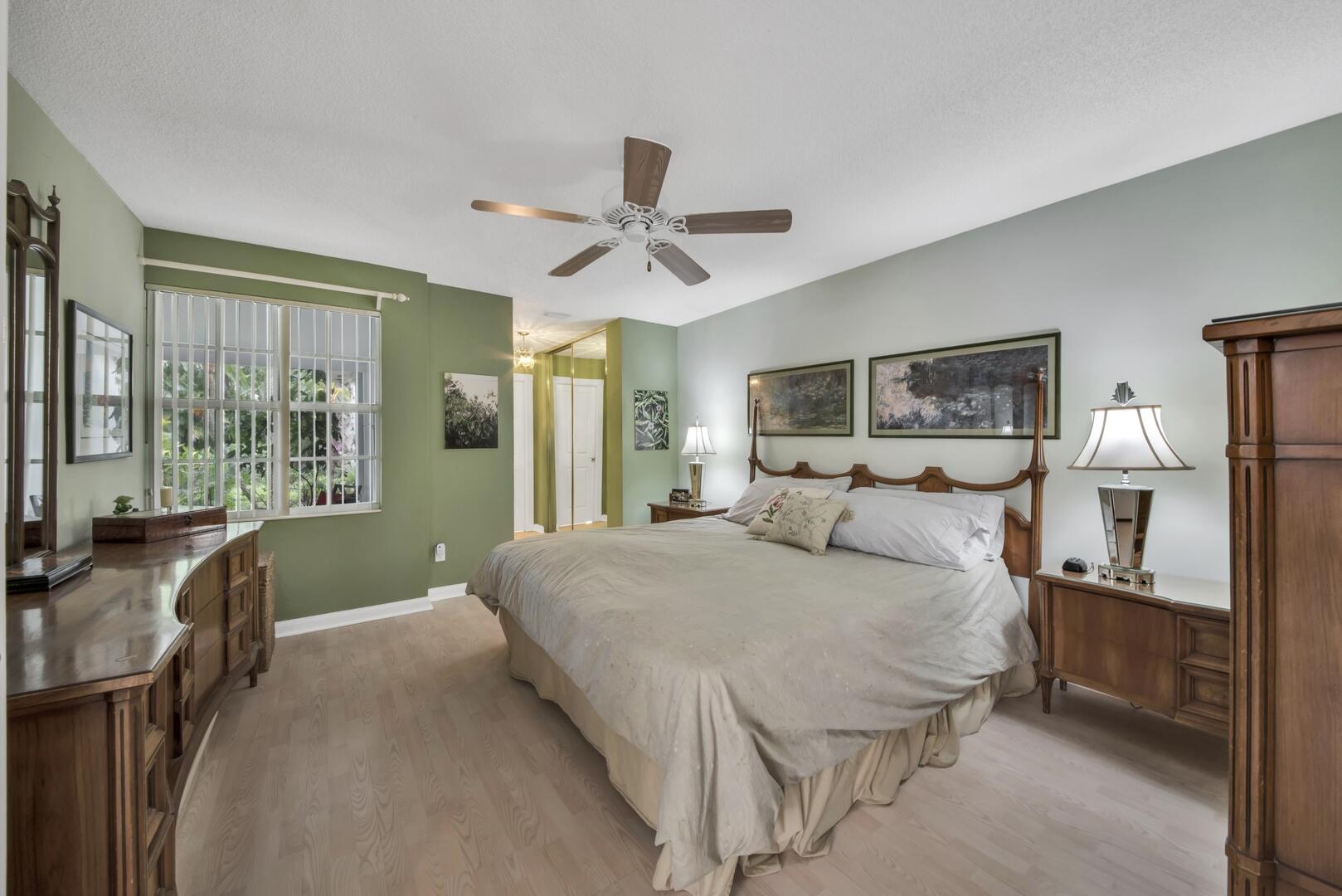 4220 Royal Oak Drive Palm Beach Gardens, FL 33410 - Photo 13 of 35 a bedroom with a large bed and a chandelier