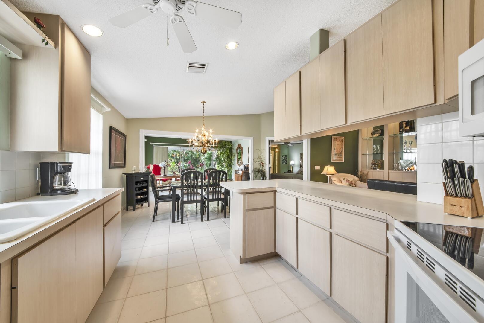 4220 Royal Oak Drive Palm Beach Gardens, FL 33410 - Photo 8 of 35 a kitchen with appliances cabinets and chairs