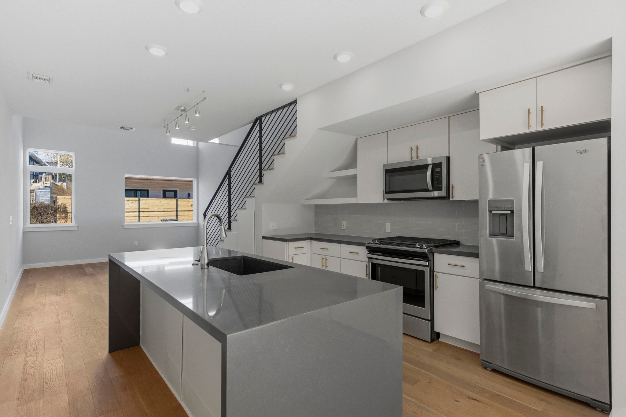 Kitchen featuring white cabinetry, appliances with stainless steel finishes, open shelves, and light wood-style floors